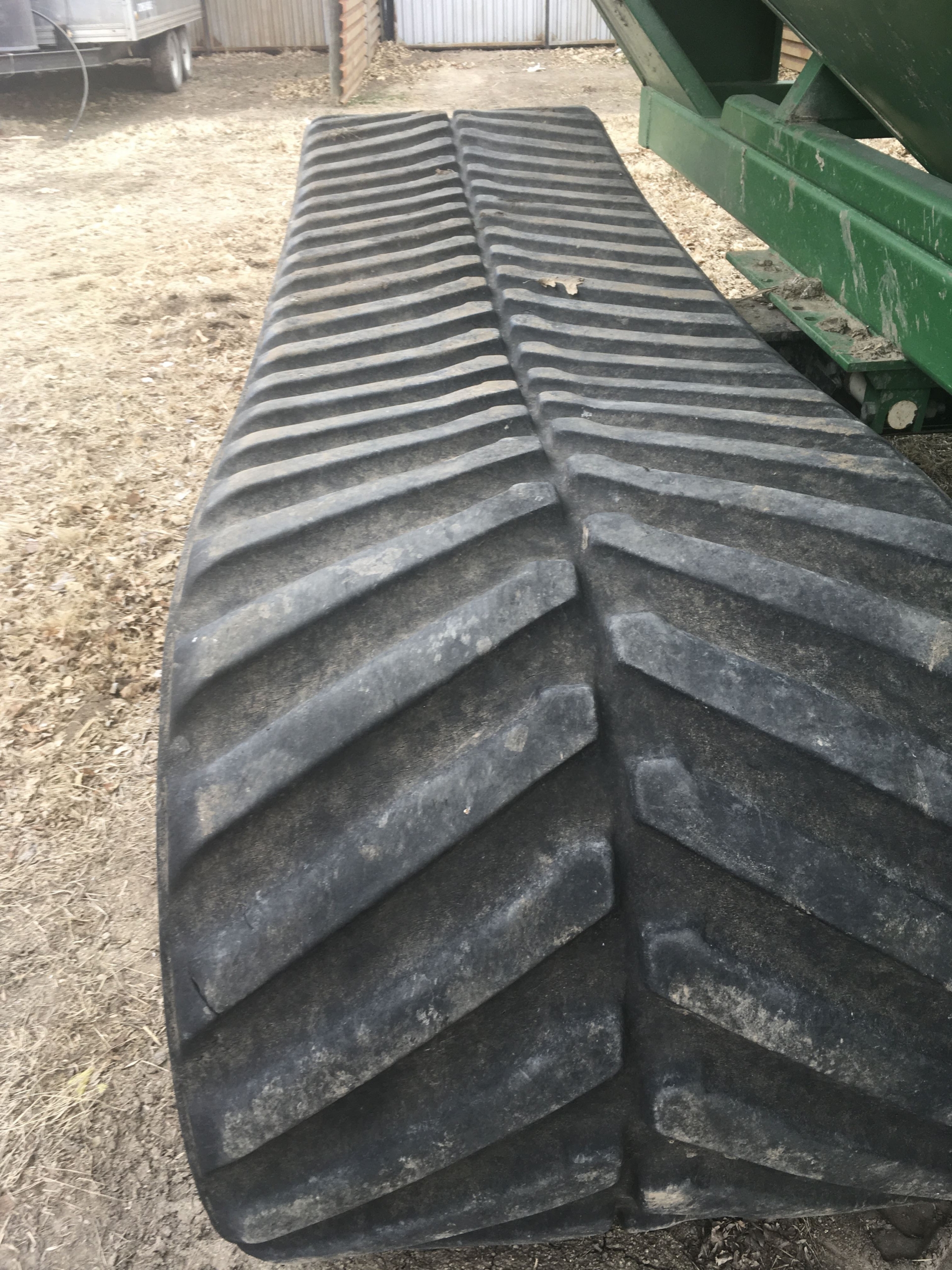 John Deere 4-track tractor pulling a tracked grain cart